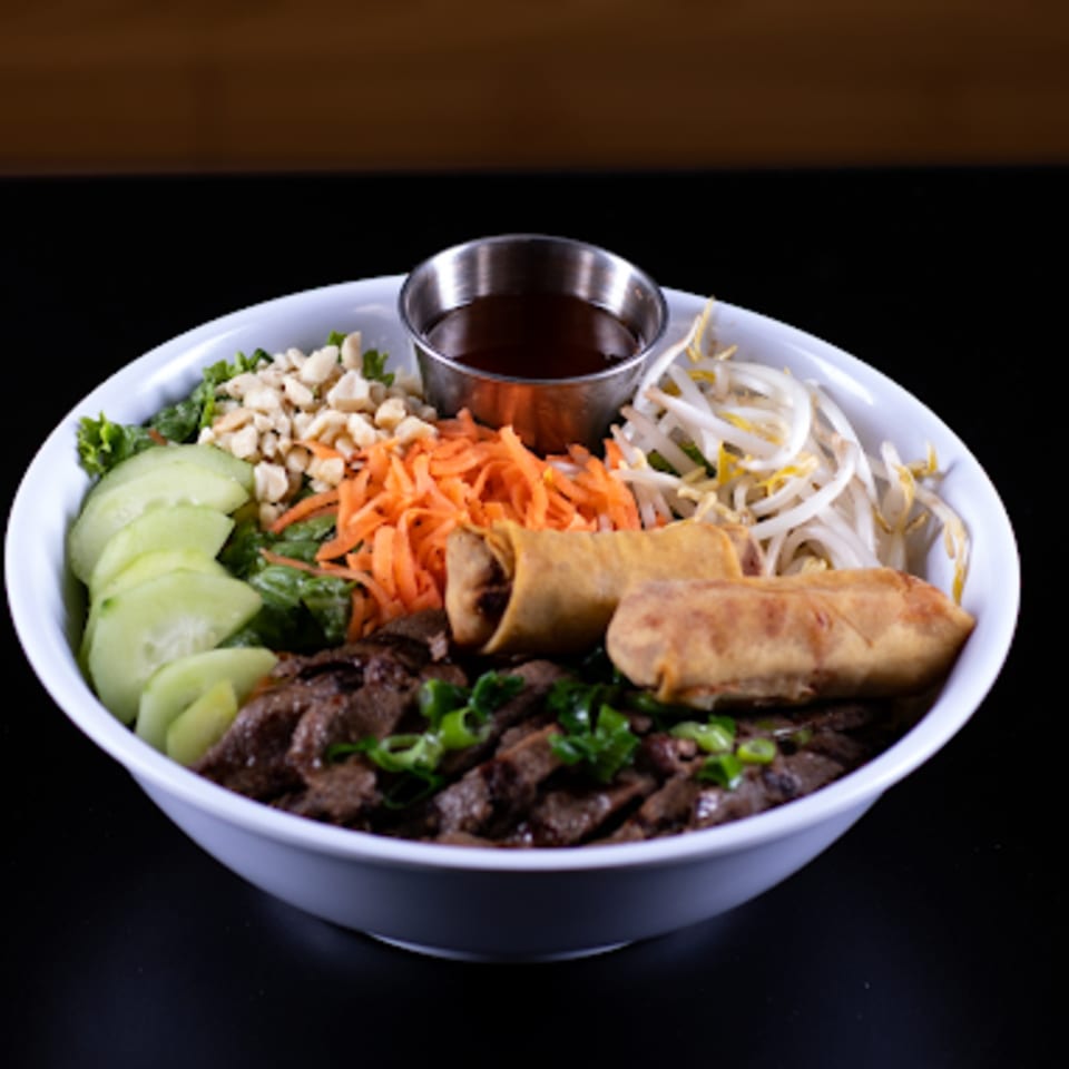 Pho Binh's Vietnamese vermicelli bowl with beef, egg rolls, and fresh vegetables.